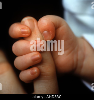 Ein drei Wochen altes Baby hält seine Hand Mütter Stockfoto