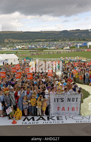 Massen von Menschen mit Bannern von gelben Ziegelsteinweg bei Make Poverty History Demonstration Greenbelt 2005 UK Stockfoto