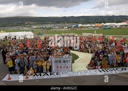 Massen von Menschen mit Fahnen folgen die yellow Brick Road bei Make Poverty History Demonstration Greenbelt 2005 UK Stockfoto