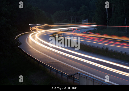 Lichtspuren von Autos und Lastwagen auf der Autobahn bei Nacht Stockfoto