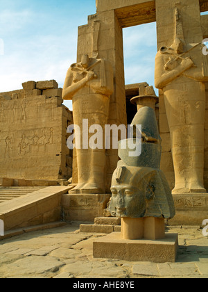 Einen gefallenen Kopf von Ramses II. mit Osiris Säulen und eine Rampe an der Portikus im Ramesseum von Luxor Stockfoto