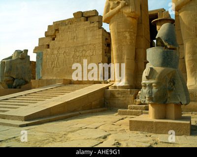 Einen gefallenen Kopf von Ramses II. mit Osiris Säulen und eine Rampe an der Portikus im Ramesseum von Luxor Stockfoto