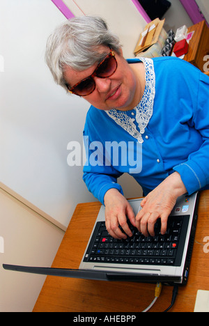 53 Jahre alte blinde Frau, die mit ihrem Laptop-Computer, UK. Stockfoto