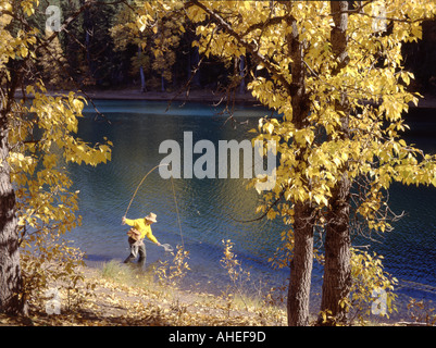 Fliegenfischer am Scout Lake in Oregon, umrahmt von fallen farbige gelbe Espe Zweige Stockfoto