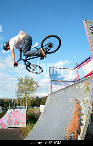 ein kleiner Junge springt mit seinem Fahrrad auf ein Viertel ein Skatepark Stockfoto