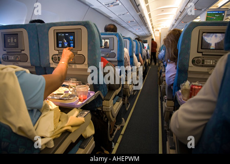 Kabine und Gang eines Passagierjet-Flugzeugs/Flugzeugs/Flugzeugs mit LCD-Fernsehmonitoren, die Filme auf einem SriLankan-Flug nach Columbo zeigen. Stockfoto
