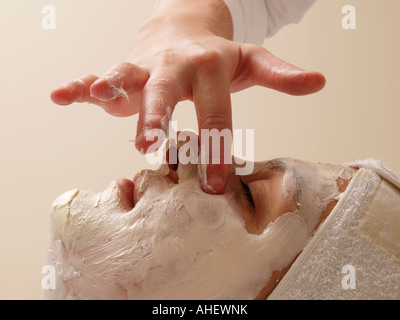 Kosmetikerin creme Anwendung auf einer Frau s Hand Finger Seite Profil Hautpflege Kosmetik Gesicht Stockfoto