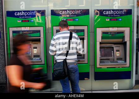 Mann Llloyds Bank Cashpoint Automaten, Putney High Street, London, UK. Stockfoto