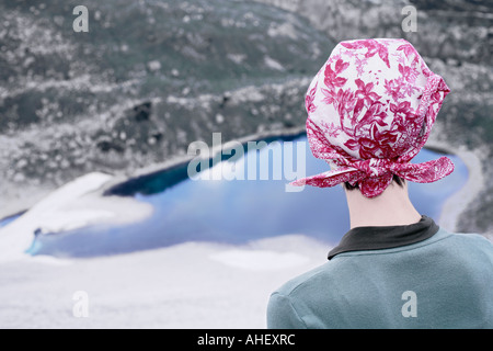 Junge Frau mit Kopftuch, die auf der Suche nach unten am Berg See Tre Cime drei Zinnen Dolomiten Alpen Italien Stockfoto