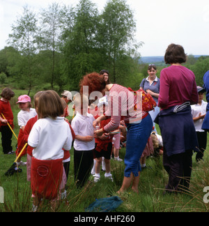 Grundschüler mit Schmetterlingsnetzen und Lehrer über die Natur Spaziergang Schulausflug im Frühjahr in Llandeilo Carmarthenshire Wales Großbritannien KATHY DEWITT Stockfoto