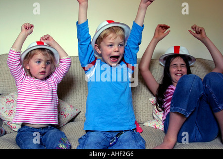 junge und 2 Schwestern beobachten Fußballspiel im Fernsehen auf Englisch zu Hause während der WM 2006 Stockfoto
