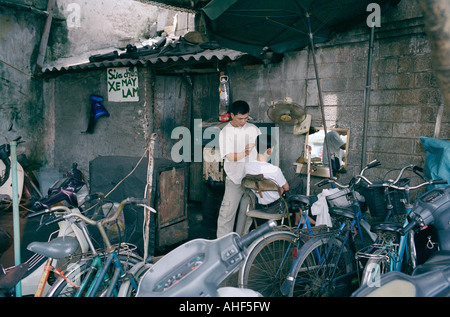 Friseur in der Altstadt von Hanoi in Vietnam in Fernost Südostasien. Arbeit Beruf Straße Leben Lifestyle Business Reportage Mann Reisen Stockfoto