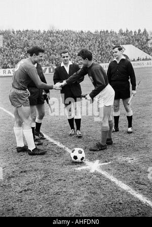 Fußball, Regionalliga West 1964/1965, Rot-Weiss Essen vs. Wuppertaler SV 1:0, Stadion an der Hafenstraße in Essen, Schiedsrichter Gerd Hennig aus Duisburg und Assistenten, Empfang der Mannschaftsführer Klaus Fetting (RWE, links) und Emil Meisen (WSV) Stockfoto