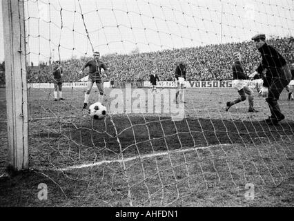 Fußball, Regionalliga West 1964/1965, Rot-Weiss Essen vs. Wuppertaler SV 1:0, Stadion an der Hafenstraße in Essen Szene von dem Spiel, goldene Tor von Eckehard Feigenspan (RWE, außen), Keeper Dieter Auris (WSV, rechts) und Rolf Mueller (WSV, 2.f.r.) Stockfoto