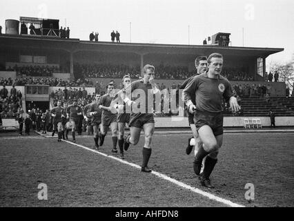 Fußball, Regionalliga West 1964/1965, Niederrhein-Stadion in Oberhausen, Rot-Weiss Oberhausen gegen Borussia Moenchengladbach 0:2, Oberhausen-Team kommt in das Stadion, Team-Kapitän Karl-Heinz Feldkamp, hinter Torwart Helmut Traska, Lothar Kobluhn Stockfoto