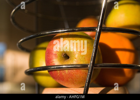 Äpfel und Orangen in Metall Obst Käfig (Schüssel) Stockfoto