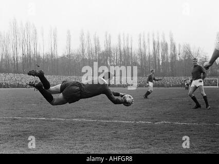 Fußball, Regionalliga West, 1965/1966, Jahn-Stadion in Bottrop, VfB Bottrop gegen Rot-Weiss Essen 0:2, Szene des Spiels, v.l.n.r.: Torwart Fred Werner Bockholt (VfB), Heinz Dieter Borgmann (RWE), Manfred Frankowski (RWE) Stockfoto