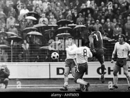 Fußball, Bundesliga, 1971/1972, Niederrhein-Stadion in Oberhausen, Rot-Weiss Oberhausen vs. FC Schalke 04 2:3, Regenwetter, Spiel bei starkem Regen, Zuschauer und Fußball-mit Sonnenschirmen, Szene des Spiels, v.l.n.r.: Reiner Hollmann (RWO), Willi Mu Fans Stockfoto