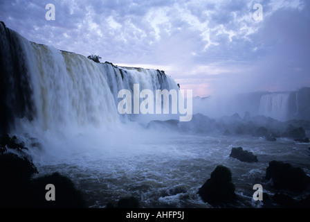Blasse rosa und blaue Wolken bei Morgendämmerung bieten eine Kulisse nach Iguazu Wasserfälle, Iguazu Falls National Park, Parana, Brasilien Stockfoto