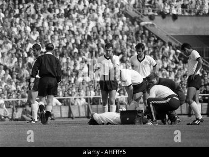 internationale Fußballspiel, 1968, Niedersachsen-Stadion in Hannover, Deutschland gegen England 1:0 verletzte Fußballspieler, v.l.n.r.: Max Lorenz (BRD), Schiedsrichter van Ravens aus den Niederlanden, verletzte Wolfgang Weber (BRD) auf Grund gelaufen, Franz Beckenbauer (BRD), Stockfoto