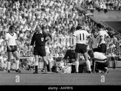 internationale Fußballspiel, 1968, Niedersachsen-Stadion in Hannover, Deutschland gegen England 1:0 verletzte Fußballspieler, v.l.n.r.: Wolfgang Overath (BRD), Schiedsrichter van Ravens aus den Niederlanden, Geoff Hurst (England), verletzte Wolfgang Weber (BRD), Max Stockfoto