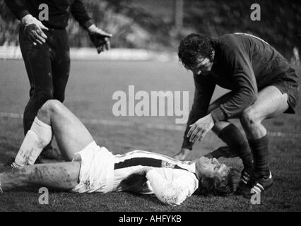 Fußball, Bundesliga, 1973/1974, Borussia Moenchengladbach im Vergleich zu 1. FC Kaiserslautern 2:2, Boekelberg Stadion verletzt-Football-Spieler, Jupp Heynckes (MG) liegt auf Grund gelaufen, zwei Kaiserslautern Spieler Pflege für ihn Stockfoto