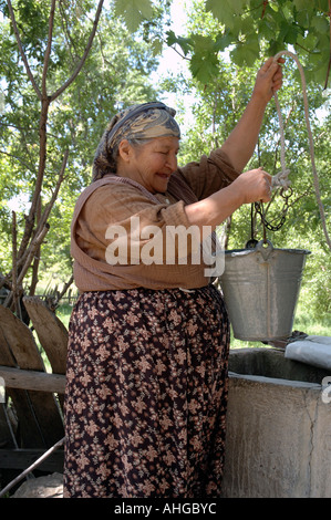 Frau, Wasser aus dem Brunnen im ländlichen Dorf Bezirgan in der Südtürkei. Stockfoto