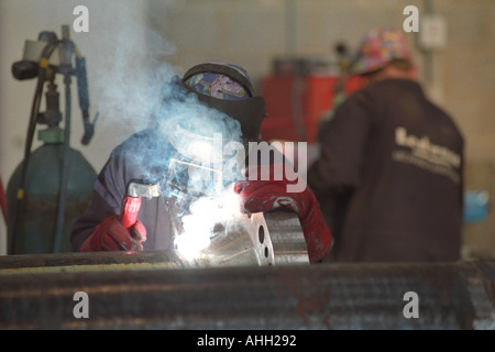 Schweißer arbeiten auf einem Rohr für die Ölindustrie in Milford Haven Pembrokeshire West Wales UK Stockfoto