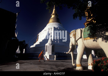 THAILAND-Novizen in ihren orangefarbenen Roben, reinigen das Tempelgelände in den frühen Morgenstunden, Wat Phra Kaeo Don Tao.Lampang Stockfoto