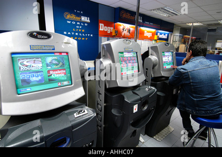 Menschen spielen Roulette auf Wetten zu festen Quoten Terminals an den Buchmacher William Hill, England, Großbritannien Stockfoto