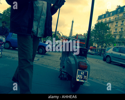 Vespa-Roller geparkt auf Bürgersteig in der Nähe von Place du Gen Gouraud mit Eiffelturm in Ferne Paris Frankreich Kreuz bearbeitetes Bild Stockfoto