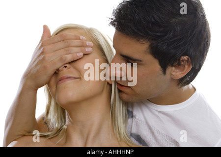 junger Mann, die Augen einer Frau zu halten geschlossen Stockfoto