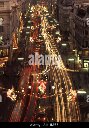 Regent Street West End of London Blick auf beleuchtete Weihnachtsdekorationen in der Nacht mit Bewegung Unschärfe Fahrzeug Ampel Trails England Großbritannien Stockfoto