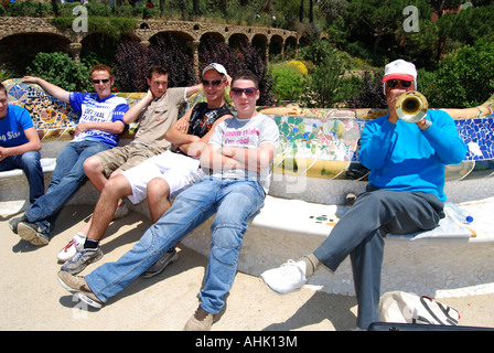 Schulgruppe von Jugendlichen mit Busker sitzen auf der Parkbank im Parc Güell Barcelona Stockfoto