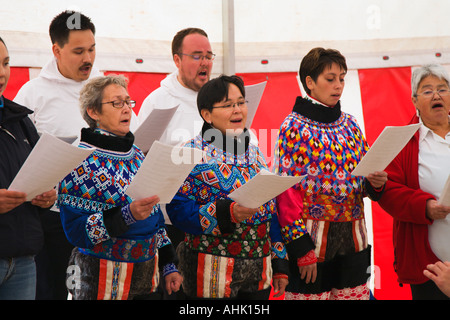 Chor der lokalen Bevölkerung in schönen Trachten mit komplizierten Mustern Sing Song Blätter in Sisimiut in Grönland halten Stockfoto