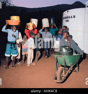 Kinder aus Lutomboni Dorf in Südafrika Dürre betroffenen sammeln Trinkwasser vom Frühjahr Wasser-Vorratsbehälter Stockfoto