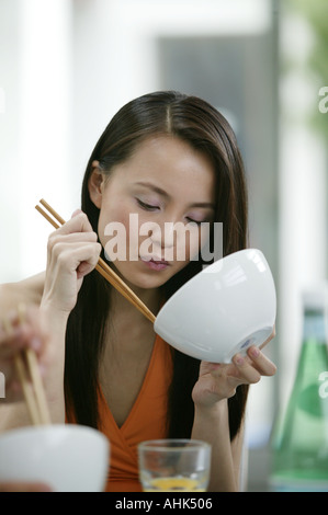 Asiatische Frau Essen mit Stäbchen Stockfoto