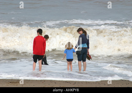 Kinder spielen in Wellen am Meer. Stockfoto