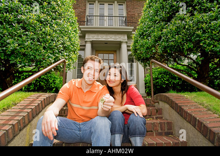Paar sitzen vor neuen Haus Stockfoto