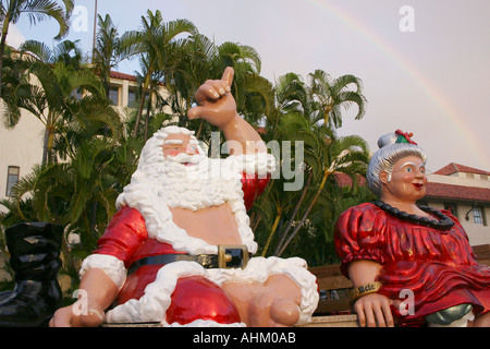 Hawaiian Santa Claus und Frau Claus auf einem Brunnen mit Regenbogen in Honolulu Hawaii Stockfoto