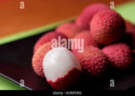 Frische Litschis auf schwarzem Teller Stockfoto