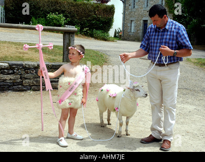 Ein kleiner Junge, sein Großvater und ein Schaf Rosebud-gepunktete vorbereiten für die jährliche Begnadigung in ihrem bretonischen Dorf Stockfoto