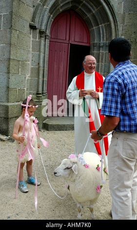 Ein Priester begrüßen 4-j hrige Hugo, seine Schafe und sein Großvater der La Feuillée Kirche für die jährliche Begnadigung Masse Stockfoto