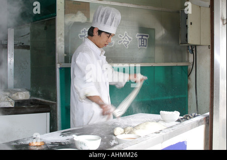 Chinesischer Koch machen Nudeln in einer Straße Garküche in Shanghai Stockfoto