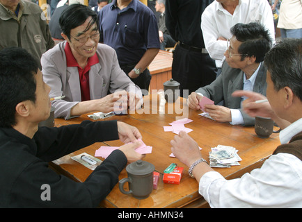 Chinesische Männer sitzen an einem Tisch im Park und spielen Karten, Shanghai, China. Stockfoto