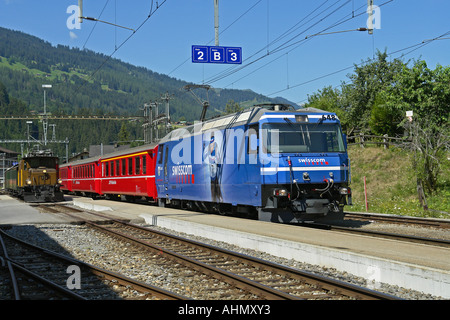 Ankunft in Grusch unterwegs in Davos und Filisur mit Motor Rhatische Bahn-Personenzug in Swisscom Livree gemalt Stockfoto