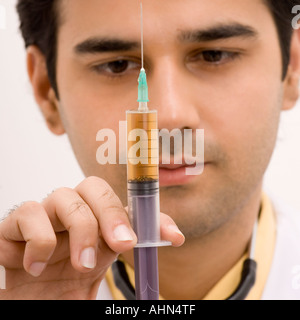 Nahaufnahme von einem männlichen Arzt hält eine Spritze Stockfoto