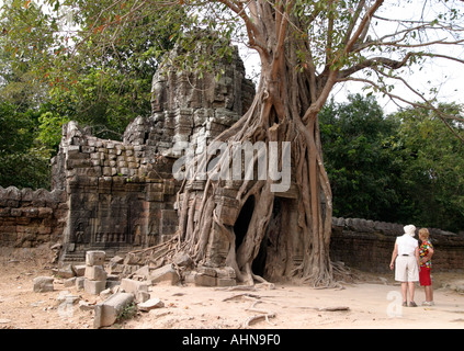 Ältere weibliche Touristen durch die Tür vom Baum überwuchert. Ta Som, Angkor, Kambodscha Stockfoto