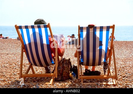 Genießen die Aussicht vom Liegestühlen an einem Sommertag am Strand von Brighton UK Stockfoto