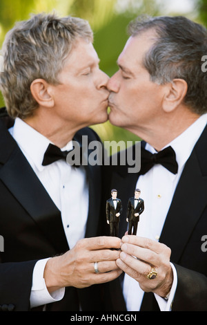 Homosexuell Brautpaar halten zwei Kunststoff Bräutigam küssen Stockfoto